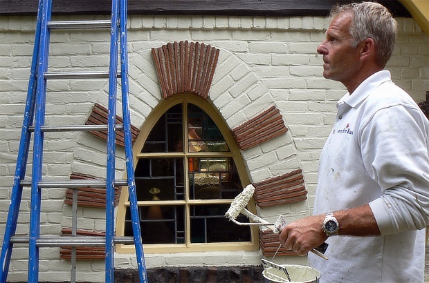 Een schilder van Vanderlaan bekijkt zijn schilderwerk